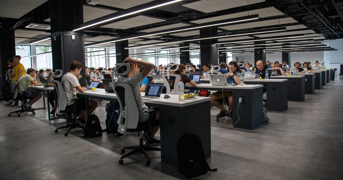 People at computers in large work space